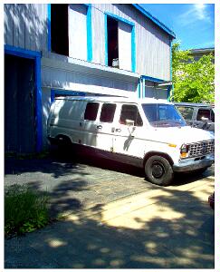 (Image: The Old AIEL Warehouse with Two
 Vans Parked Outside)