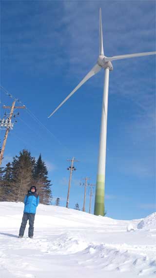 Neal Livingston at the foot of a Black River Wind Turbine